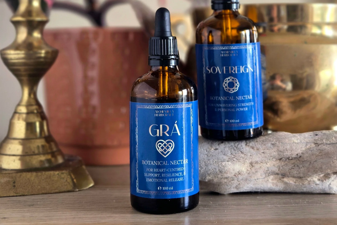 Amber dropper bottles on a wood table with decor in the background