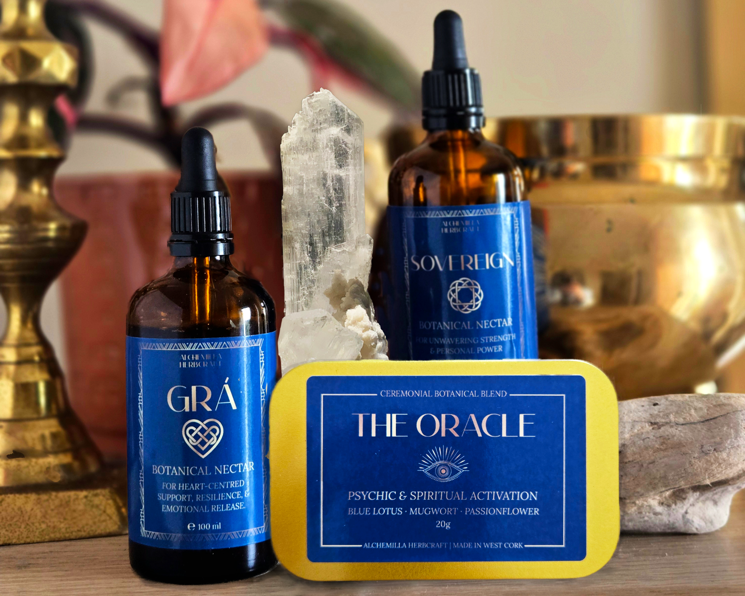 Two bottles of 'Gra' and 'The Oracle' with a crystal and candle in a decorative setting.